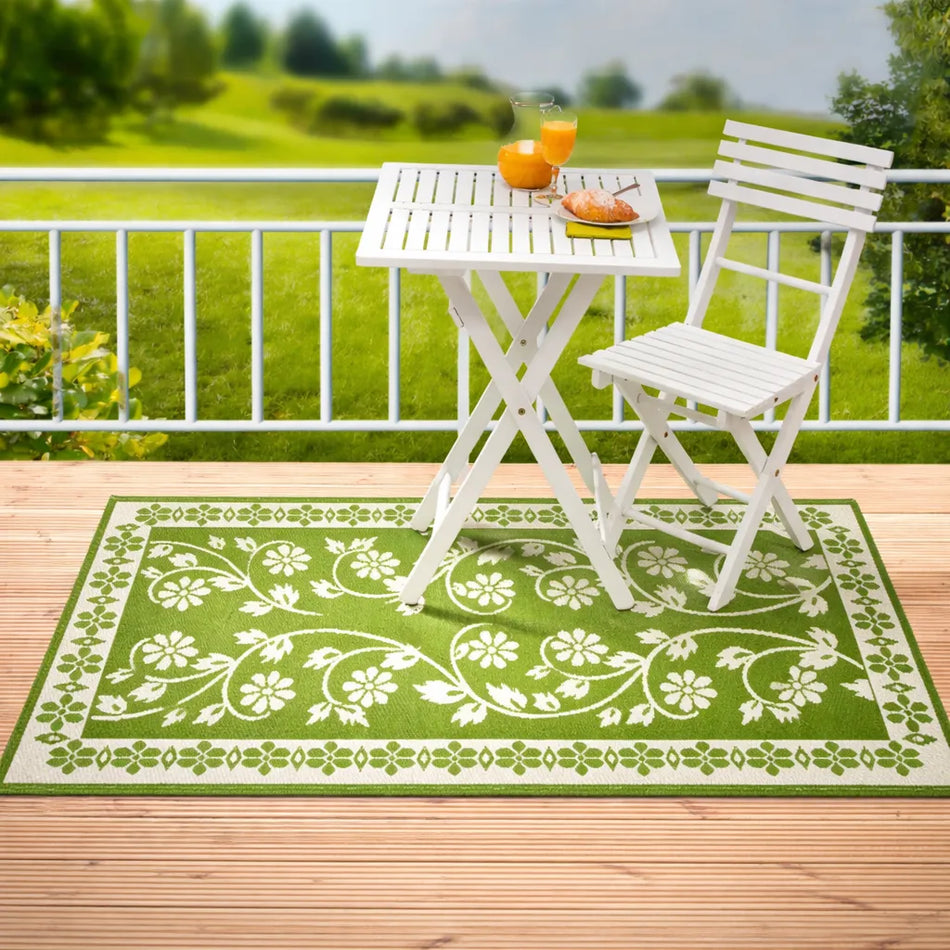 Outdoor-Wendeteppich grün mit floralem Muster als robuster Balkon- und Terrassenteppich unter Bistroset