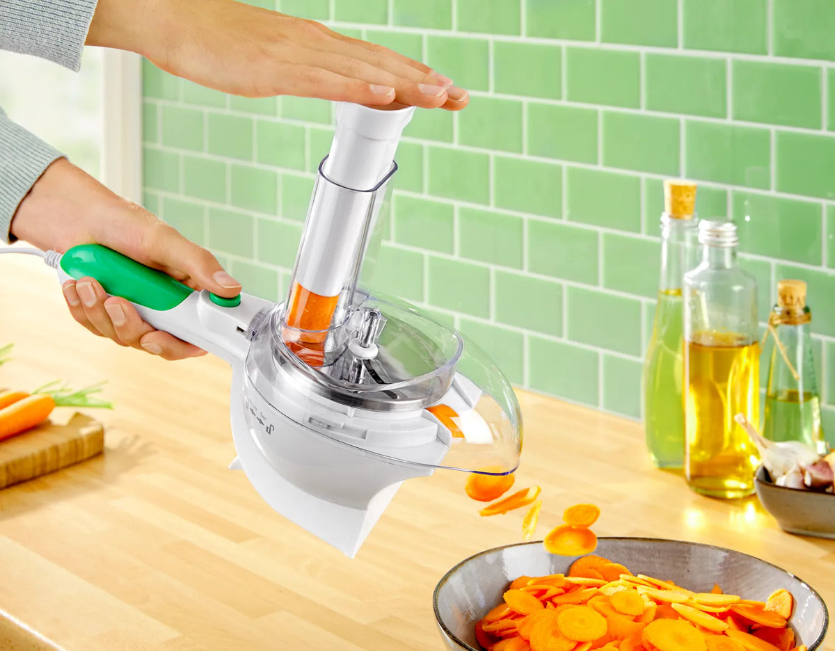 Elektrische Handreibe schneidet Karotten in Scheiben – kompakte Küchenhilfe zum schnellen Reiben und Zerkleinern